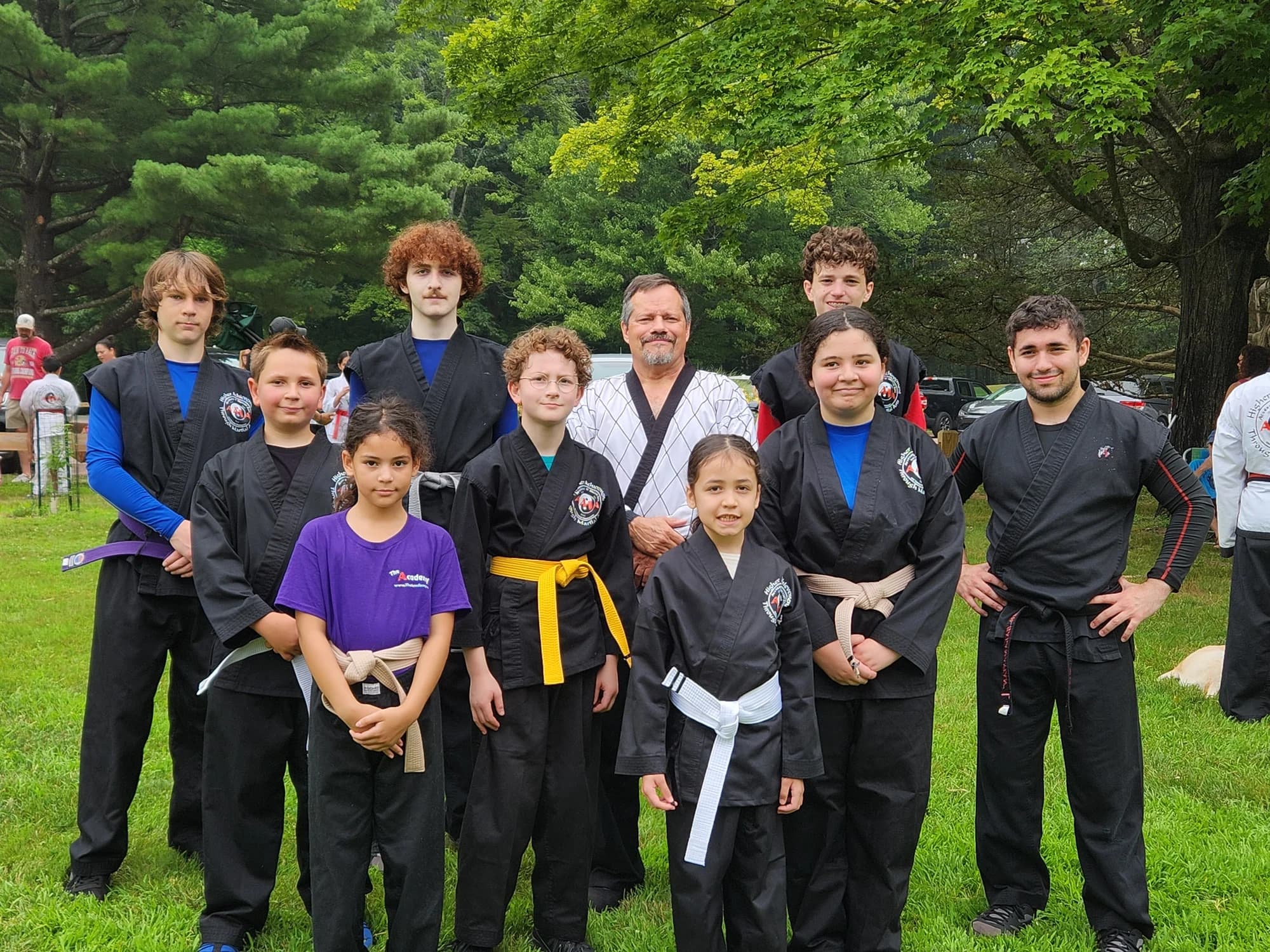 Academy children, teens, and instructors gathered outdoors after training