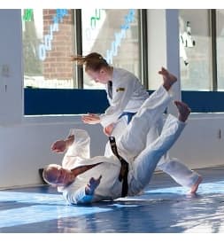 Adult martial arts students practicing a partner technique at The Academy